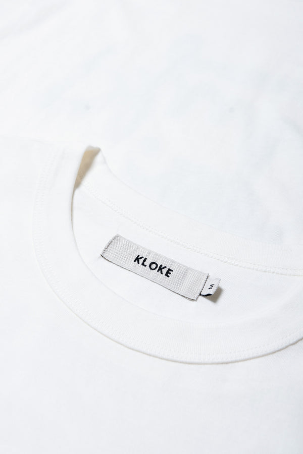 Close up neckline shot of The Pfutze Print T Shirt in White and Green. A classic t-shirt cut from a soft cotton jersey, with a thick rib neckline and straight hem. Available in 5 sizes.