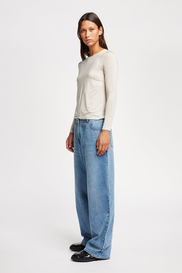 Front side view of Model wearing Kloke straight-leg jeans in mid-blue Japanese denim, featuring a mid-rise waist and relaxed silhouette