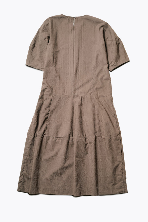 Back of the Scoria Dress, a long-panelled cotton seersucker dress with voluminous sleeves, structured panel details, and a fuller skirt, perfect for an effortless summer look. Available in 5 sizes.