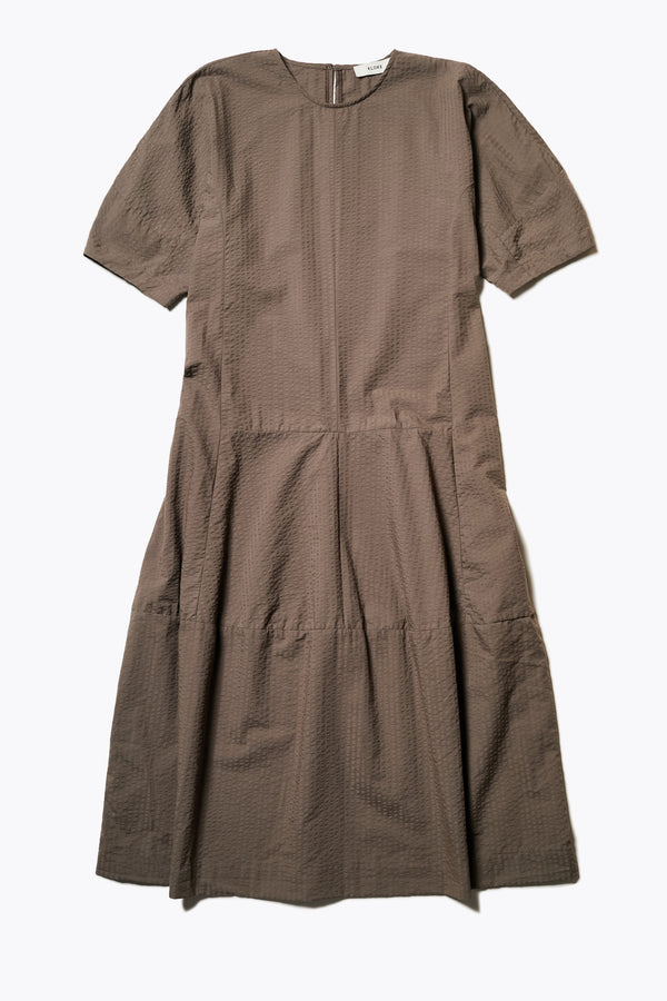 The Scoria Dress, a long-panelled cotton seersucker dress with voluminous sleeves, structured panel details, and a fuller skirt, perfect for an effortless summer look. Available in 5 sizes.