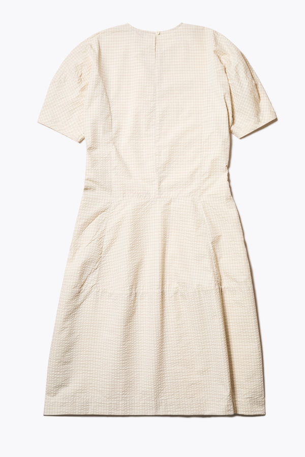 Back of The Scoria Dress in Ecru beige, a long-panelled cotton seersucker dress with voluminous sleeves, structured panel details, and a fuller skirt, perfect for an effortless summer look. Available in 5 sizes.