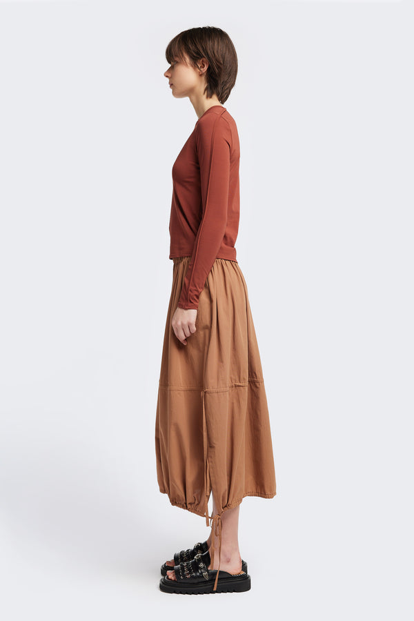 Side view of the Seclude long sleeve top in Brick. A Slim-fit crew neck top in soft cotton stretch, featuring an exposed bound seam curving across the back and sleeves.