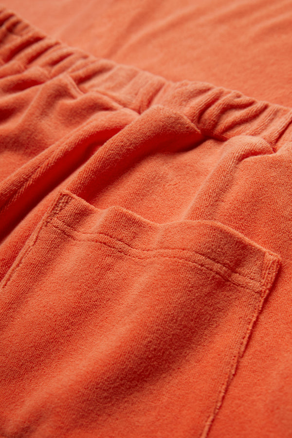 The Prone Towelling Track Pant is crafted from an Okeo-tex standard cotton terry in Tangerine Orange. The track pant has an elasticated waistband and two back pockets.