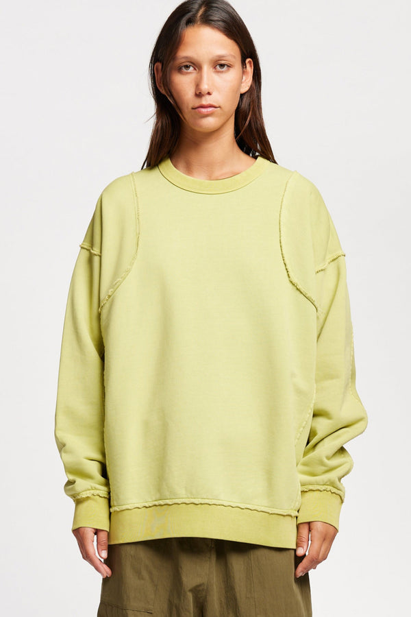 women - model wearing Unisex format oversized crew neck sweater in chartreuse with clean panelled design and raw flat-locked seams, displayed from the front.
