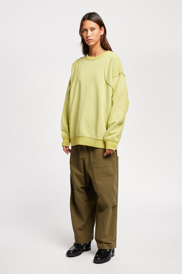 women - model wearing Unisex format oversized crew neck sweater in chartreuse with clean panelled design and raw flat-locked seams, displayed from the front.