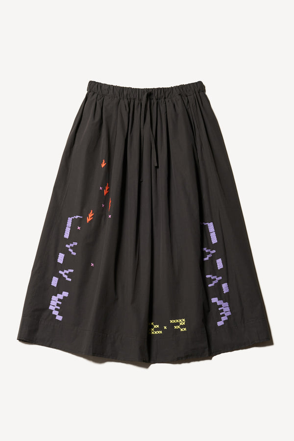 Flat front view of the Black Universe Embroidered Skirt showcasing Arecibo-inspired motifs.