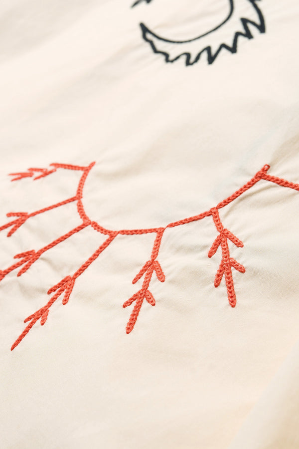 Close up embroidery details of the Ecru Universe Embroidered Skirt showcasing Arecibo-inspired motifs.