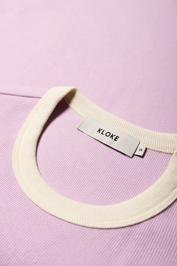 Close up of the Veil Rib Tee a slim-fit ringer tee in ribbed cotton, featuring a vintage 70's-inspired design with contrasting neckline and sleeve details. Available in 5 sizes.