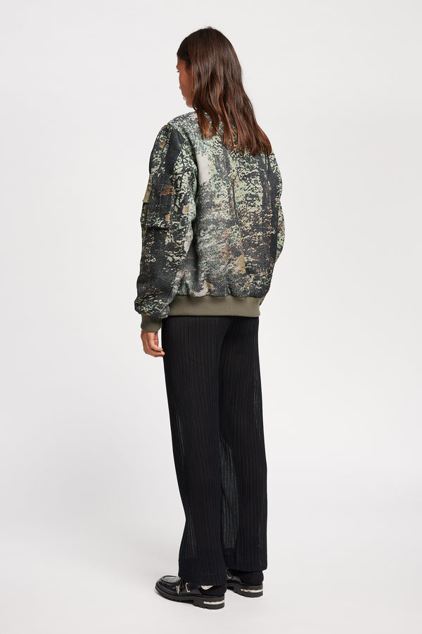 Women Back of Unisex bomber jacket in Green Print woven jacquard with real tree camouflage, featuring dropped shoulders, ribbed trims, and full-length front zip.