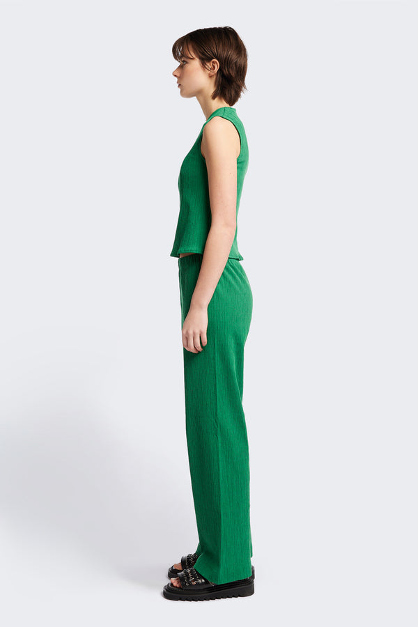 Side view of the Aeon Crinkle Top in Green, featuring a sleeveless design, panelled bustline, high neckline, and concealed back zip. Crafted from structured crinkled crepe fabric. Available in 4 sizes.