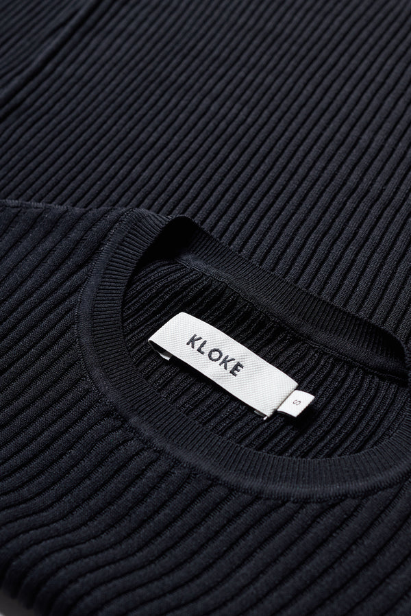 Close-up of the Black Verse Knit Tee drop-stitch knit and rib trims.