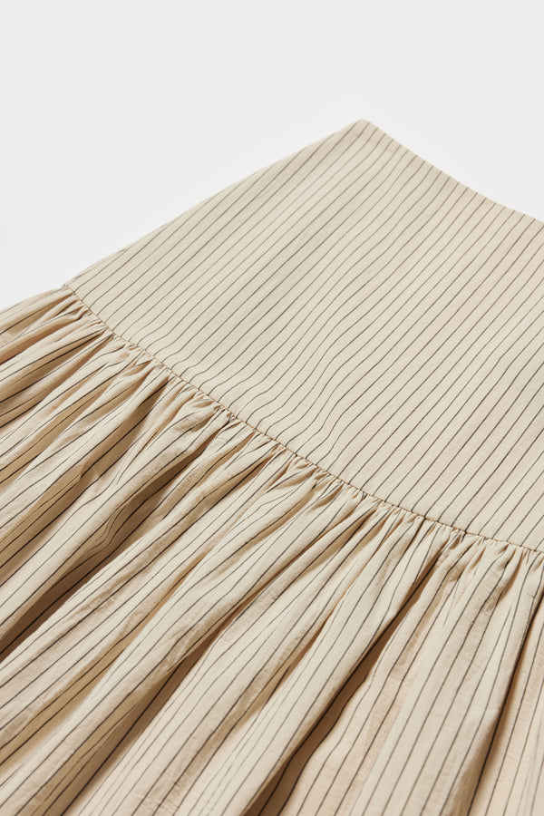Detail shot of the Ecru and Black Pin Stripe Panelled cotton skirt with gathered full silhouette, wide yoke waist, and invisible back zip closure.