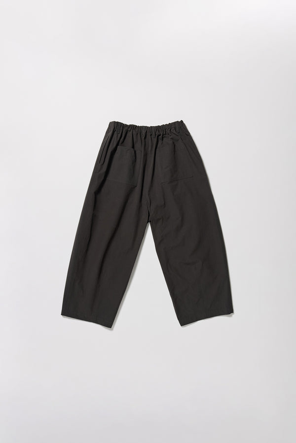 Flat back of the Factor Pleat Pant black slate. A relaxed silhouette defined by an encased elastic waistband. 