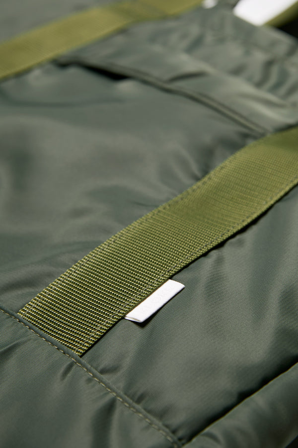 Close up of the Influx Padded Bag, a practical tote with a padded look and feel. Made from a strong, quick dry nylon in Olive Green.