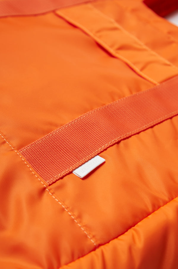 Close up of the Influx Padded Bag Orange, a practical tote with a padded look and feel. Made from a strong, quick dry nylon. 