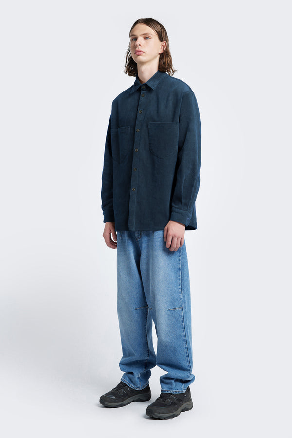 The Corner Cord Shirt made from thick-wale corduroy in Petrol Blue styled with the Grail Jeans Mid Blue Fade.