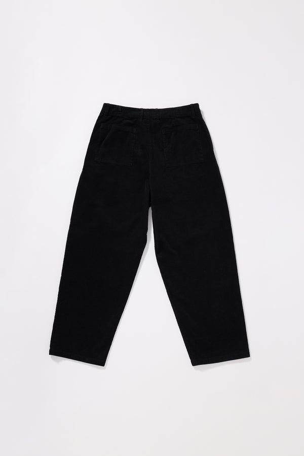 Flat Back view of the black Dissolve Cord Pant showing two back patch pockets and loose semi-tailored silhouette in garment double over-dyed corduroy