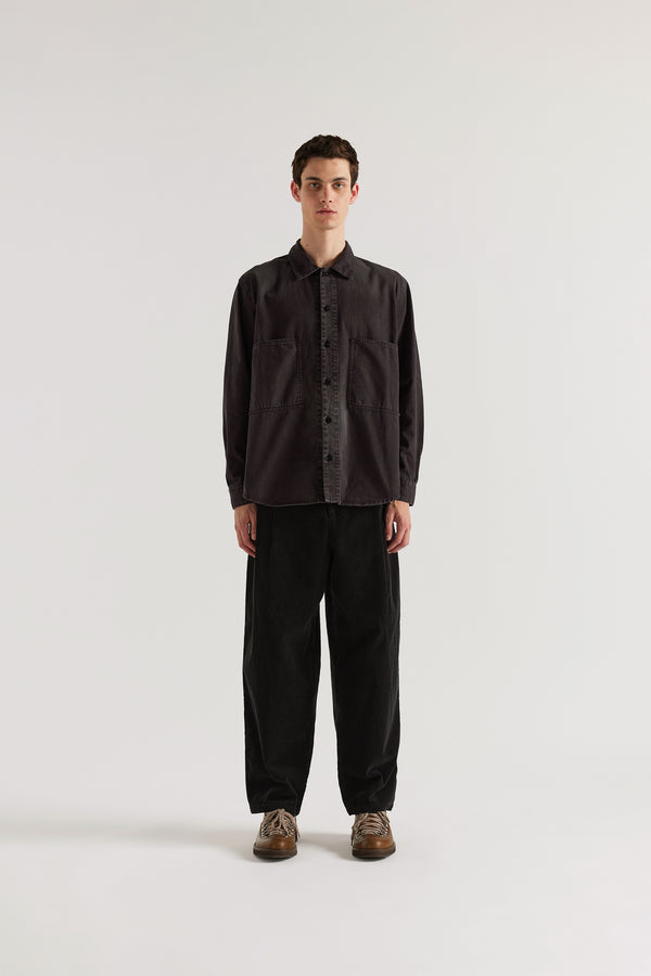 Vintage Black Dissolve Cord Pant front view on model showing loose double-pleated silhouette, button waistband with belt loops and garment double over-dyed corduroy