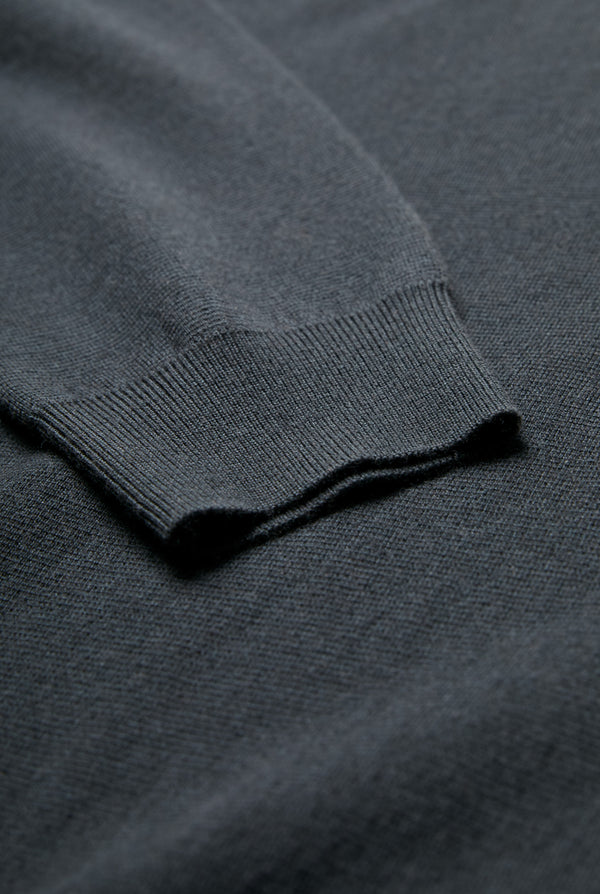 Close up of the Dose Merino Knit Sweater in Charcoal with hints of deep forest green and ribbed cuffs. This Sweater is made from 100% Merino.