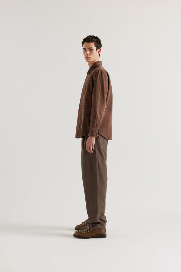 Side profile of brown fade oversized denim shirt showing the relaxed silhouette and curved hem detail.