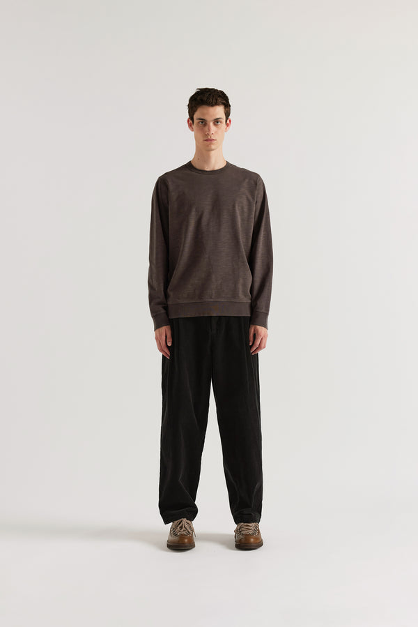 Front profile of model in the washed black/ licorice relaxed long-sleeve slub cotton T-shirt showing the easy fit.
