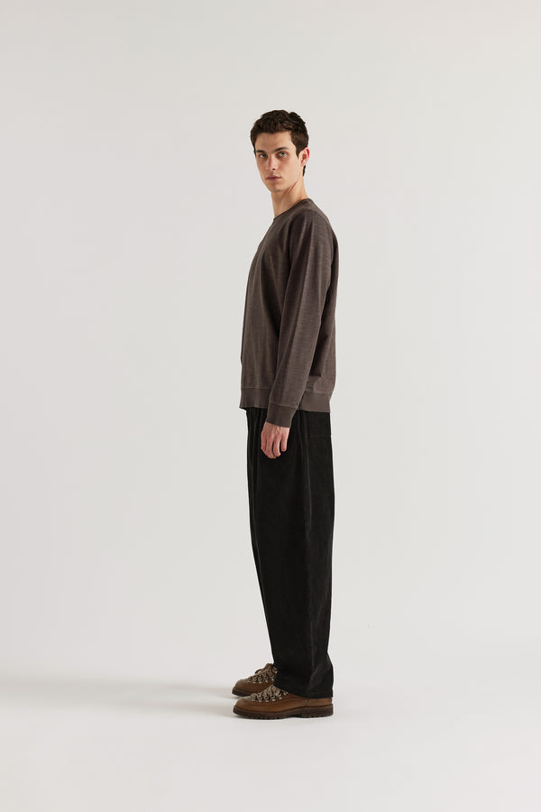Side profile of model in the washed black/ licorice relaxed long-sleeve slub cotton T-shirt showing the easy fit.