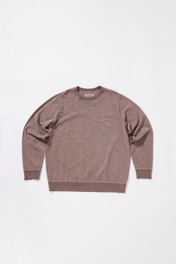 Flat front of the Relaxed long-sleeve T-shirt in pigment-dyed slub cotton with a classic crew neckline. 