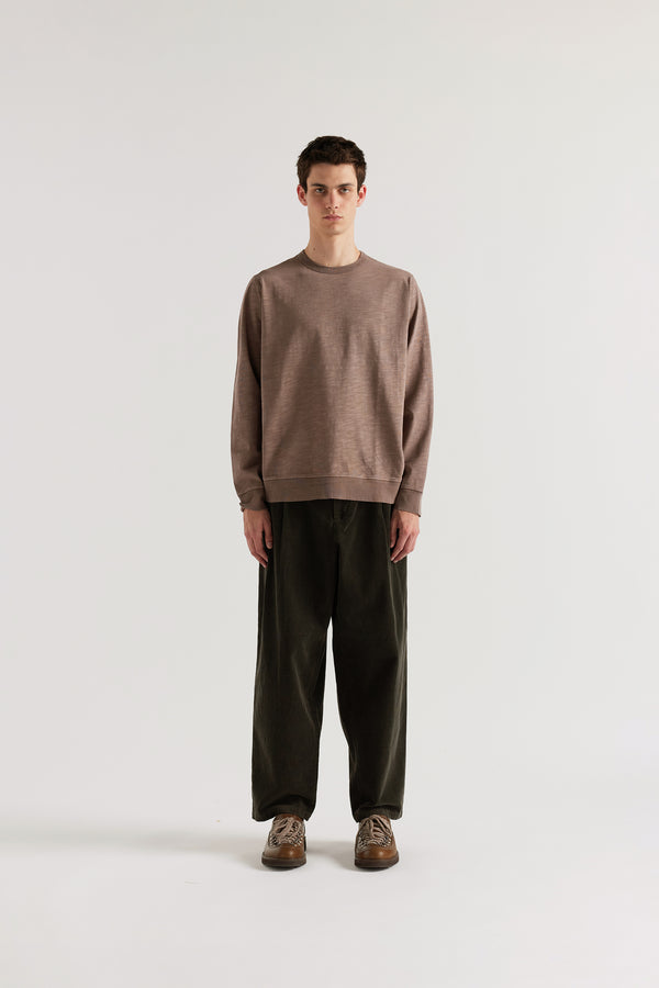 Front of male model in brown Relaxed long-sleeve T-shirt in pigment-dyed slub cotton with a classic crew neckline.
