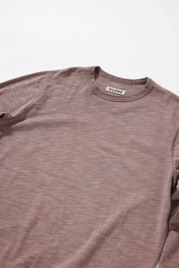 Close-up of the brown pigment-dyed slub cotton fabric showing its textured surface and soft finish.