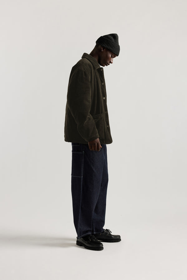 Side view of the Lull Jean in dark indigo Japanese denim with a relaxed loose fit, cargo pockets and elasticated waistband.