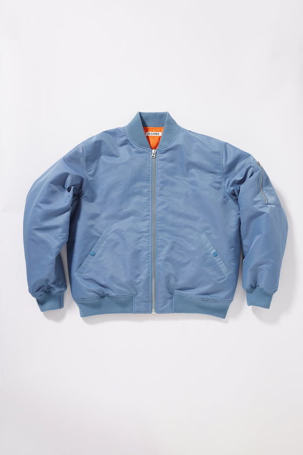 Flat Front of the Grey Blue Lyric Bomber Jacket in garment-washed nylon with zip front, tonal ribbing and multiple utility pockets.