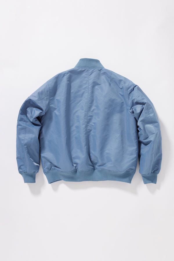 Flat Back of the Grey Blue Lyric Bomber Jacket in garment-washed nylon with zip front, tonal ribbing and multiple utility pockets.