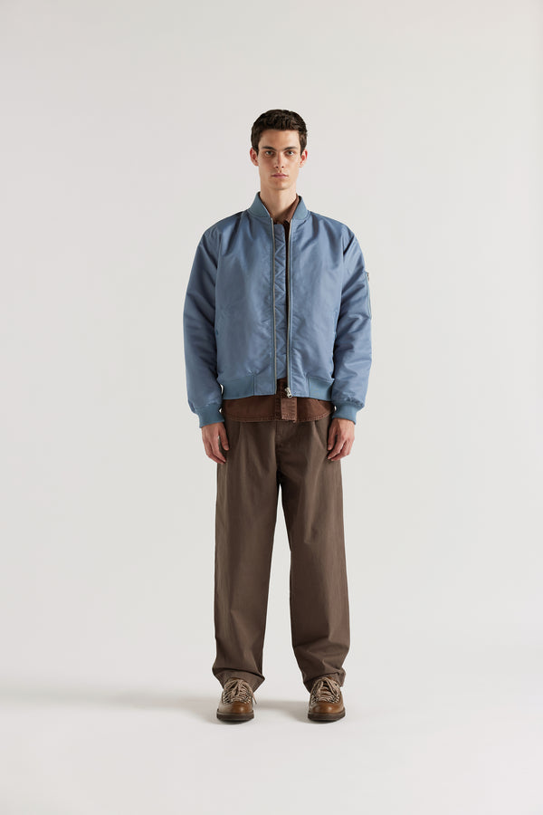 Front of model in the Grey Blue Lyric Bomber Jacket in garment-washed nylon with zip front, tonal ribbing and multiple utility pockets.