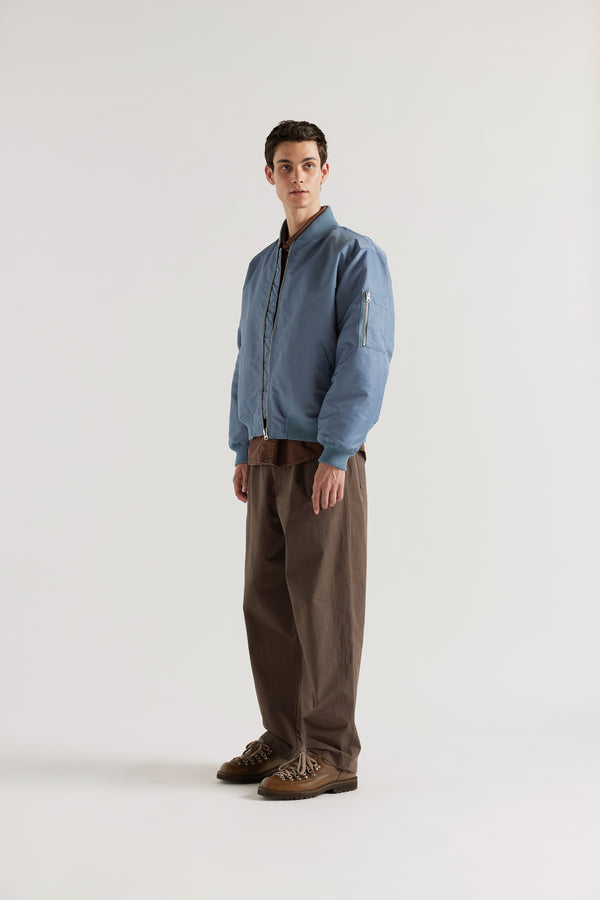 Front of model in the Grey Blue Lyric Bomber Jacket in garment-washed nylon with zip front, tonal ribbing and multiple utility pockets.