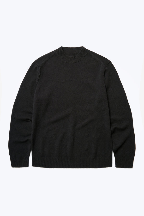 The front of the Photic Cashmere Sweater, a relaxed crew-neck jumper with exposed linked seams at the shoulders and knitted in a wool/cashmere blend in Black. This sweater is light, warm and soft. 