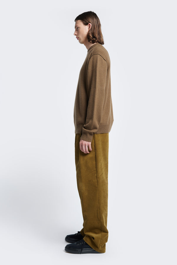 Side profile of the Photic Cashmere Sweater Brown, a relaxed crew-neck jumper with exposed linked seams at the shoulder. Knitted in a soft wool/cashmere blend. 