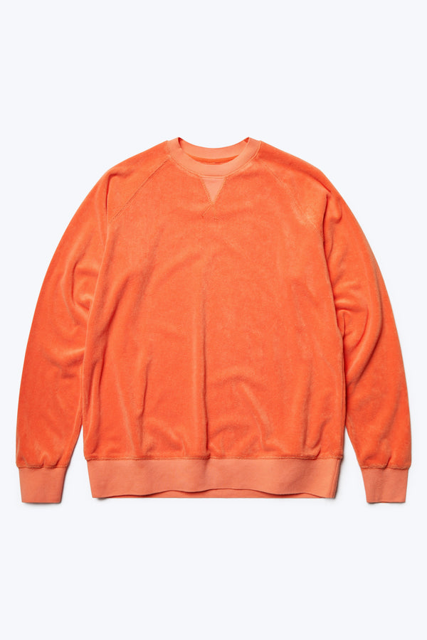 The front of the Range Towelling Sweater Tangerine, a relaxed fit sweater inspired by an old-school track-and-field pedigree. Made from plush, 100% cotton Okeo-tex standard 100 micro terry-towelling with rib band trim, V insert, flatlock stitch and raglan coverstitched sleeve.