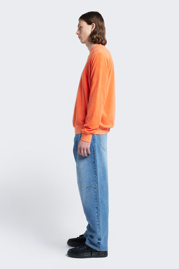 Side profile of the Hero Towelling Sweater Tangerine, a sweater inspired by an old-school track-and-field pedigree with a relaxed fit. Made from plush, 100% cotton Okeo-tex standard 100 micro terry-towelling.