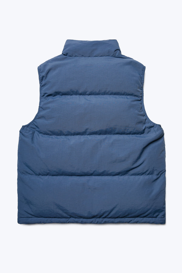 The back of the Reset Quilted Puffer Vest Blue made with 100% post-consumer down fill. Has a high neckline for warmth and elasticated arm holes for comfort. 
