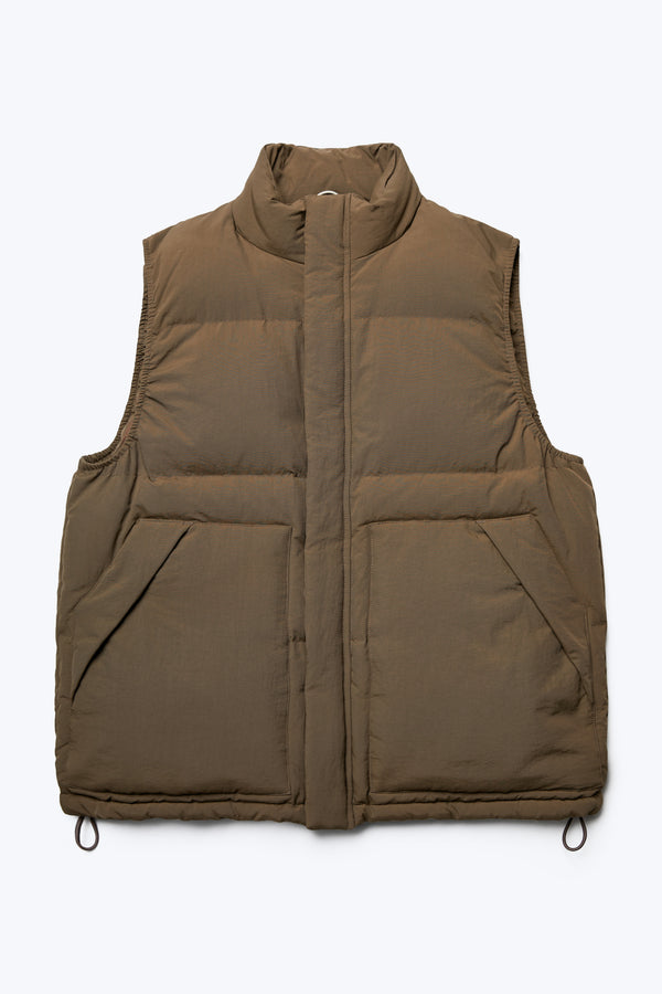 The front of the Reset Quilted Puffer Vest Brown, with a high neck, centre zip and stud closure, internal and side pockets and adjustable toggled elastic waist. Made with 100% post-consumer down fill. Available in five sizes. 