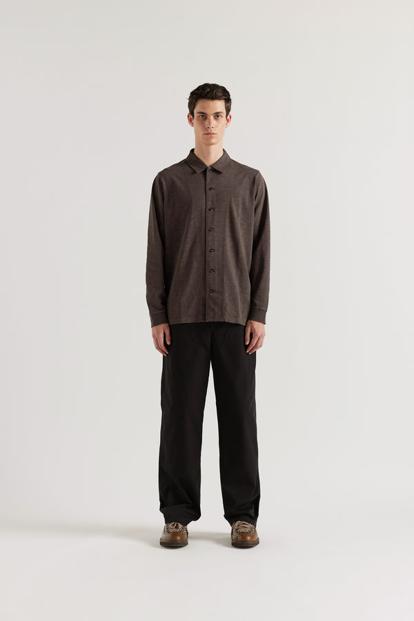Front of the male model in black licorice Shadow Jersey Shirt in a pigment-dyed slub cotton with a relaxed boxy fit and button-through front.