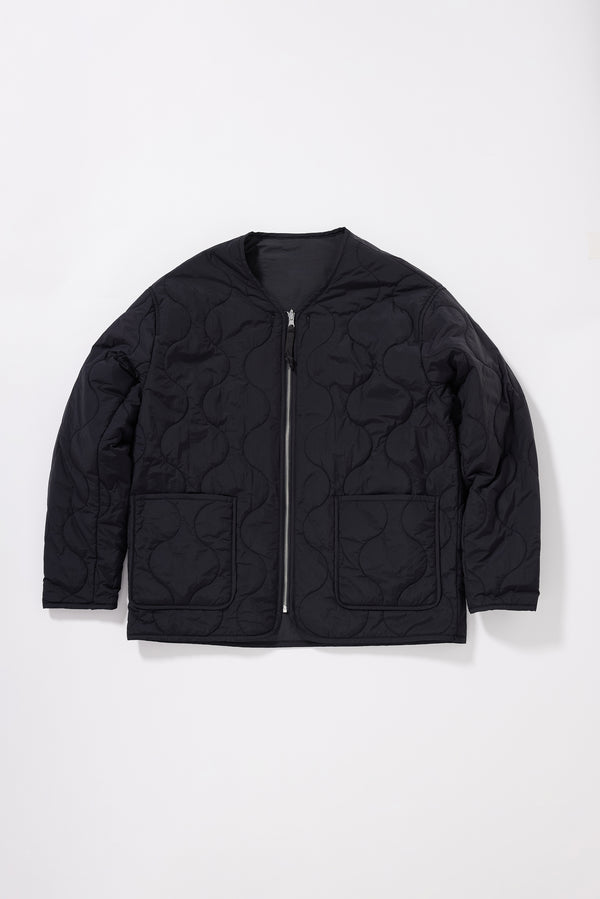 Flat front of the vintage black ripple-patterned quilted stitching on recycled nylon reversible jacket

