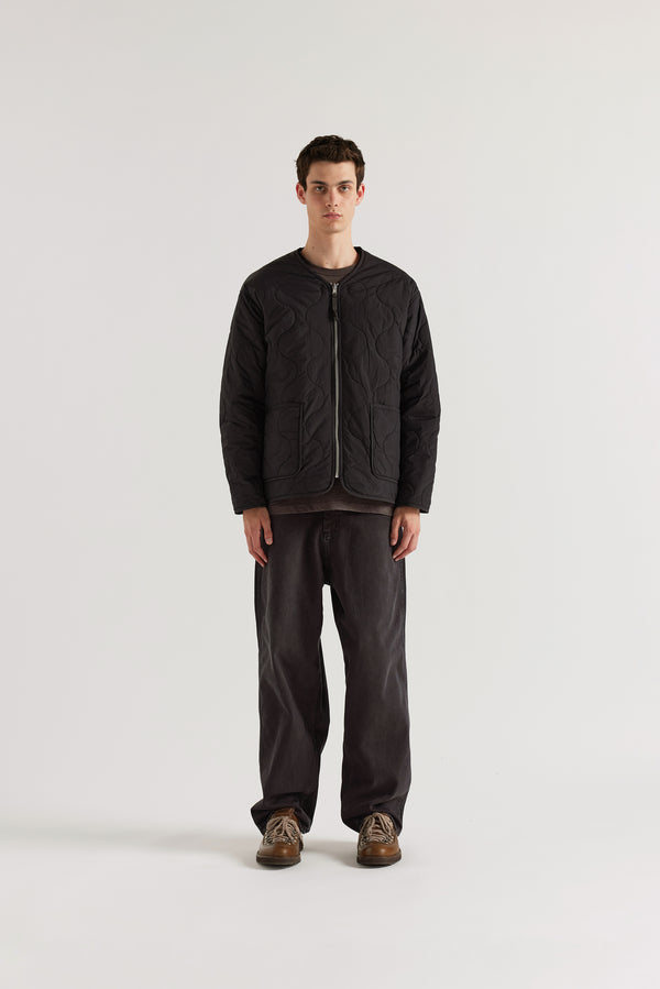 Front of the vintage black Reversible recycled nylon jacket shown with ripple-patterned stitching facing outward and front pockets visible
