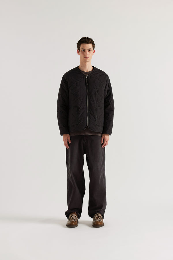 Front of the vintage black Reversible recycled nylon jacket shown with ripple-patterned stitching facing outward and front pockets visible