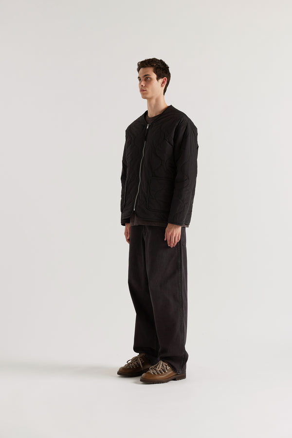 Front of the vintage black Reversible recycled nylon jacket shown with ripple-patterned stitching facing outward and front pockets visible