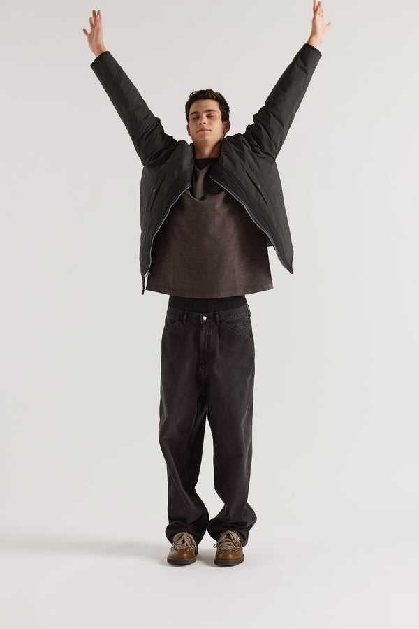 Front of the vintage black Reversible recycled nylon jacket worn plain-side out, showing a clean minimalist finish with accessible pocket detail