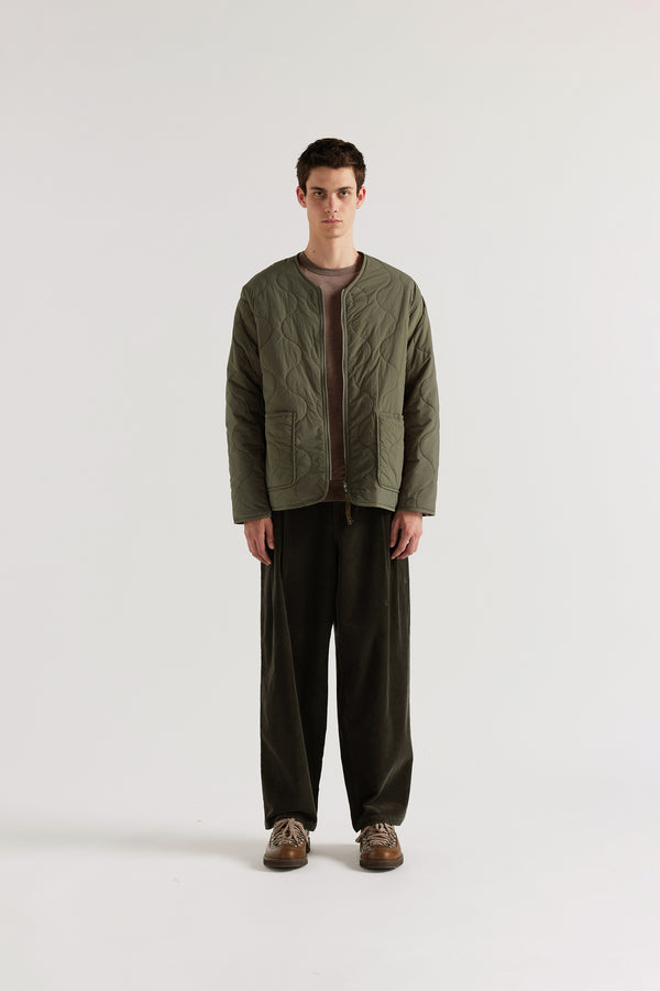 Front of the Olive Reversible recycled nylon jacket shown with ripple-patterned stitching facing outward and front pockets visible