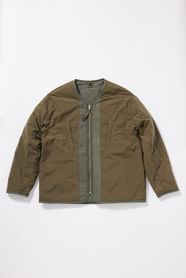Flat front of the Olive plain-side out, showing a clean minimalist finish with accessible pocket detail
