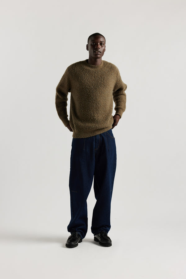 Model in Olive Spore Knit Sweater front view showing crew neck raglan silhouette, fluffy marle-flecked alpaca blend knit and exposed seam linking detail