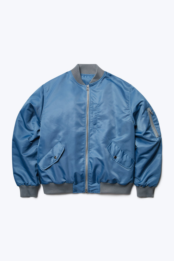 The Strata Bomber Jacket Blue is a  lightweight nylon jacket with quilted lining, double opening YKK hardware, rib trim and multiple pockets with zip and press stud closure. 